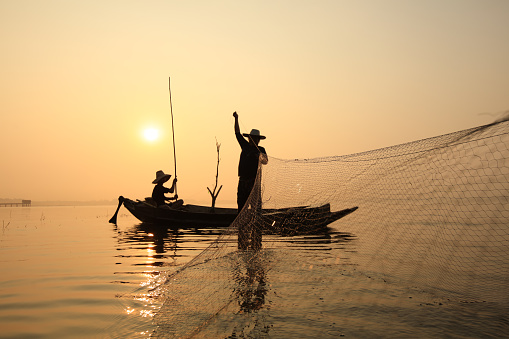 Fisherman lay their bamboo made fishing net in the Brahmaputra river in a cold winter evening, in Guwahati, Friday, Jan.3, 2020.