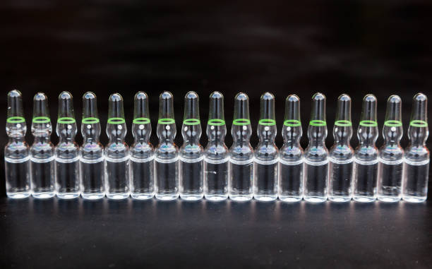 small glass ampoules with medicines on a black background. - fungus science bottle glass photos et images de collection