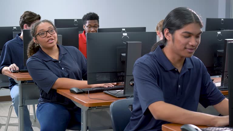 Multiracial high school students working in computer lab