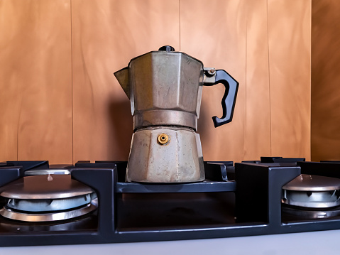 Boiling Coffee on gas in kitchen. Moka pot, italian traditional coffee maker, on the stove. High quality photo