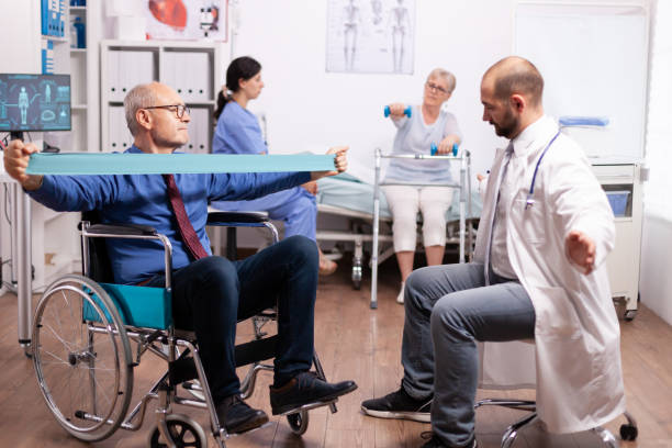 istock Physiotherapist working with senior man in modern clinic 1907725223
