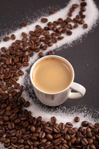 photo a cup of espresso surrounded by aromatic coffee beans, creating a visually pleasing background. With a touch of sugar, it promises a delightful coffee experience captured in this image. hot drink, roasted, fresh, copy space, aromatic, arabica