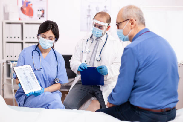 istock Doctor discussing about bone disease with senior man pointing at tablet pc 1907743994