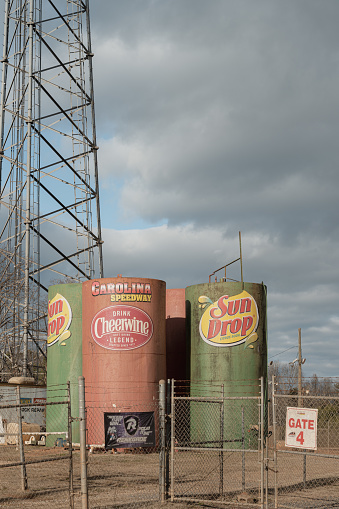 Gastonia, North Carolina, United States, 30 Dec 2023: Carolina Raceway in Gastonia, NC, a water tank at the base of a cell tower proudly showcases Sun Drop and Cheerwine ads.