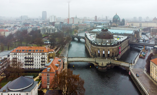 Drone point of view on  junction of Spree river and Kupferrgraben canal , Monbijou bridge next to Bode Museum.    Berlin Cathedral (Dome), and base of  Berlin Tv Tower( Fernsehturm) and Rotes Rathaus also. 3  Ukrainian flags over museums buildings!