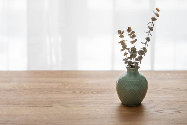 istock Wooden oak table top with a green vase with eucalyptus branches 1907836447