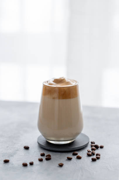 istock Whipped Dalgona coffee with milk. Instant  coffee in a glass with beans on a blue background with morning light. 1907838550