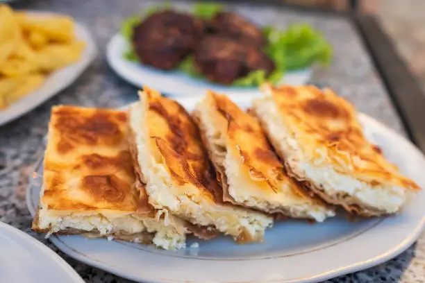 Burek with cheese - national dish, popular in the Balkans. Byrek traditional Albanian food made with cheese. Balkan Bakery Breakfast Serving of Byrek Cheese Pie with Feta and Flaky Filo Pastry