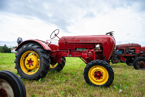 Lyngdal, Norway - June 27 2023: Red vintage Porsche Diesel tractor in a field.