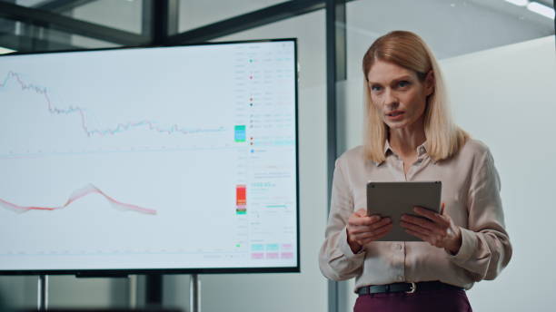 istock Smiling businesswoman presenting screen strategy. Closeup speaker holding tab 1907873759