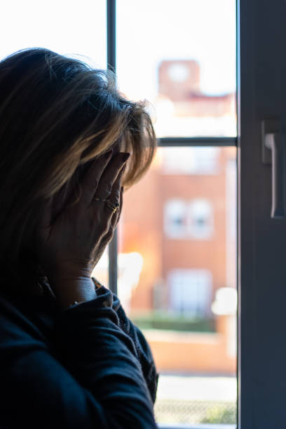 istock Woman with hands on her face suffering from mental problems and depression. 1907890328
