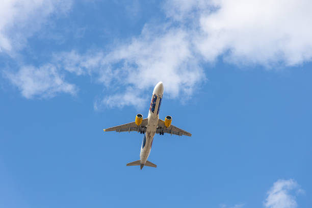 Paris, France - 07 07 2023: White and blue plane with chassis is landing on a sky with clouds background