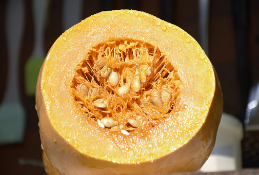 cut pumpkin close-up. the vegetable pulp and seeds are clearly visible. autumn background. Halloween holiday. A tasty, healthy product rich in vitamins and fiber. food security