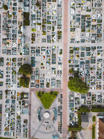 Aerial perspective of cemetery adjacent to a quaint small town, top view of burial ground for people who passed away, beautiful architecture of graveyard