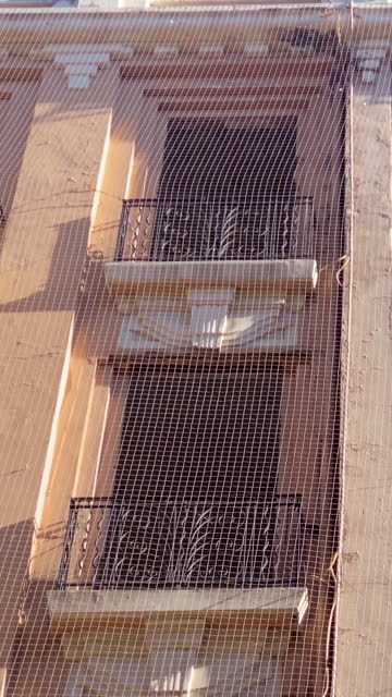 Building facade covered with protective net