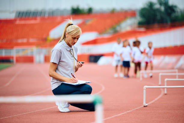 istock Athletics coach writing on clipboard during sports training at the stadium. 1908081439