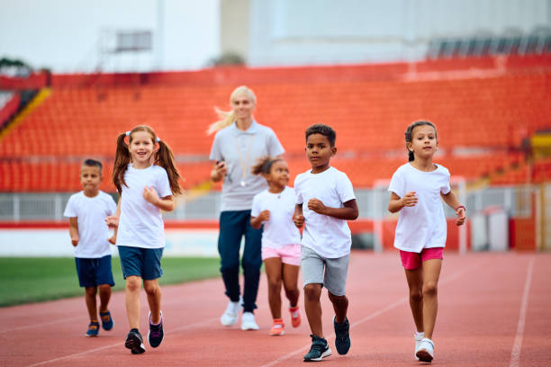 istock Group of kids running during exercise class at the stadium. 1908081941