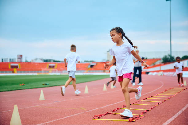 istock Little girl having PE class on running track at the stadium. 1908082995