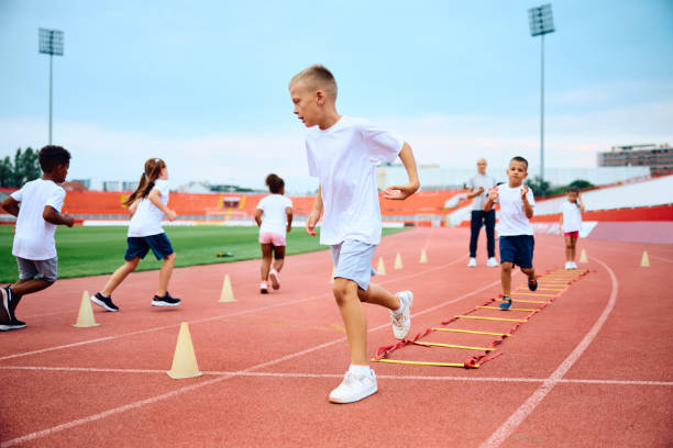 istock Little boy running during exercise class at the stadium. 1908083004