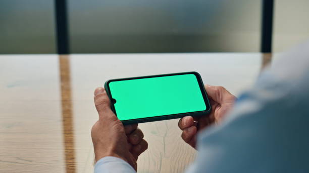istock Businessman hands watching chromakey device workplace. Man holding mockup phone 1908102028