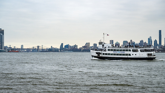 Hoboken, USA - February 15, 2023: New York waterway ferry boat on the Hudson River against Manhattan, New Jersey, United States