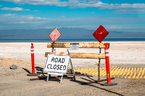 A road blockade and closed sign with warnings not to enter at the Salton Sea