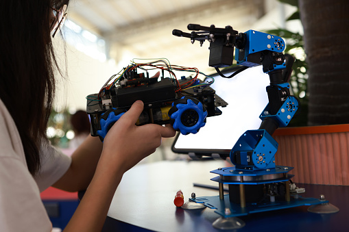 High school student concentrates while building the robot
