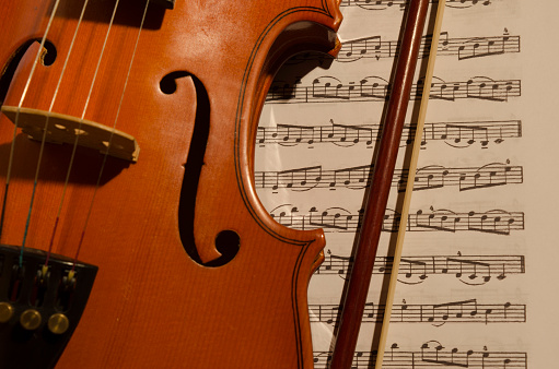 violin perched on classical music score, musical studio environment