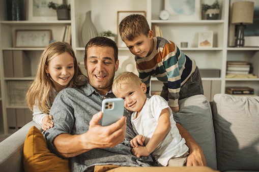 Father making selfie with three kids.