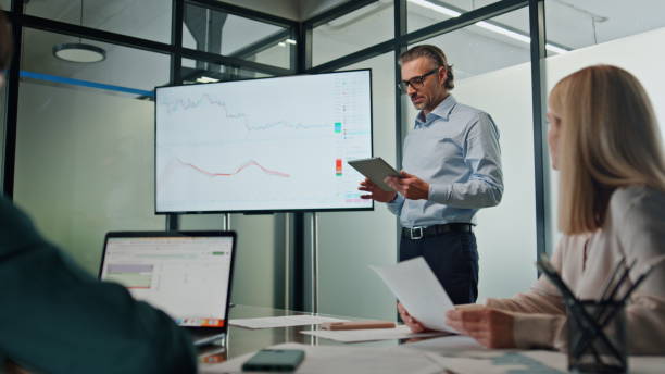 istock Serious boss leading presentation in boardroom. Mentor consulting employees 1908202694