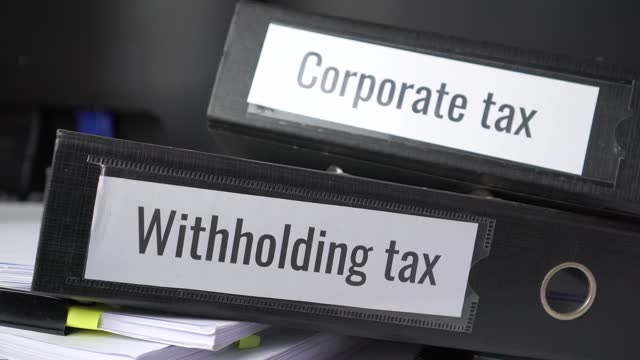 Stack of taxes binders report concept: Document of Withholding tax and corporate tax for accountant. withholding tax sometimes applies to royalties, rent or even sale duty must be paid to government