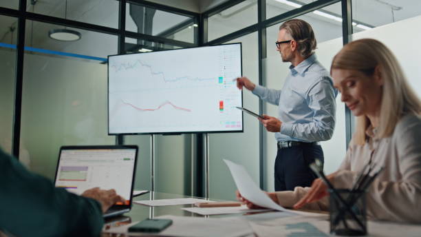 istock Leader man presenting project cabinet. Businessman pointing on screen diagrams 1908260235