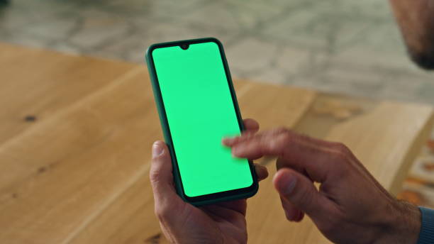 istock User scrolling chromakey smartphone at cabinet closeup. Man hand holding device 1908296624