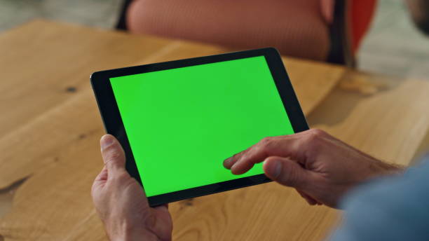 istock Man finger swiping greenscreen tablet office. Close up specialist scrolling tab 1908306943
