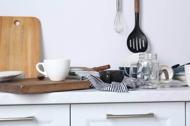 istock Many dirty utensils and dishware on countertop in messy kitchen 1908307456