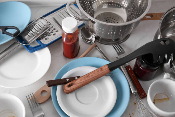 istock Many dirty utensils and dishware on countertop in messy kitchen, above view 1908307587
