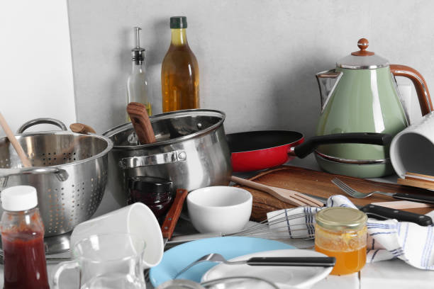 istock Many dirty utensils, cookware and dishware on countertop in messy kitchen 1908307679