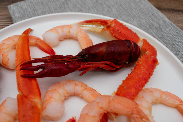 cangrejos de río, camarones y patas de cangrejo en un plato para servir para una comida de plato hervido de mariscos - prawn seafood plate serving dish fotografías e imágenes de stock