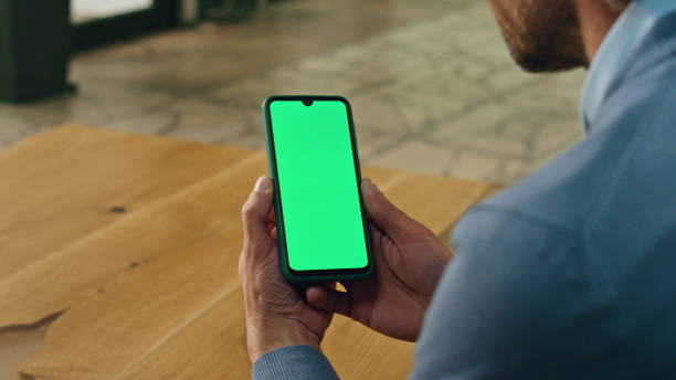 istock Boss hands holding mockup smartphone indoor closeup. Businessman using phone 1908308133