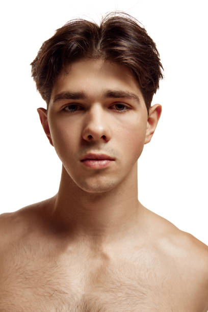 istock Close up portrait of young attractive brunette man with bare shoulder looking at camera against white studio background. 1908332369