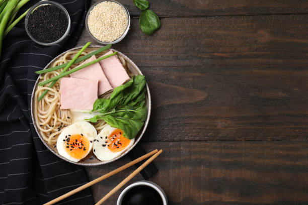 istock Delicious ramen with meat served on wooden table, flat lay and space for text. Noodle soup 1908340244