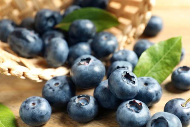 istock Fresh tasty blueberries on wooden table, closeup 1908362123