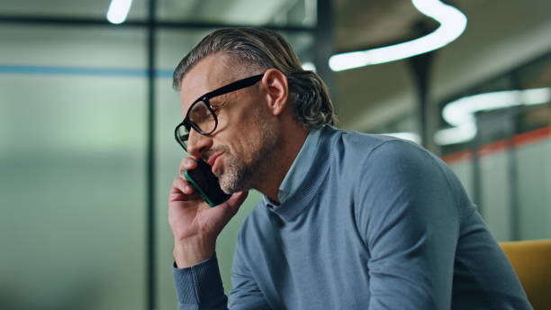 istock Confident businessman talking cellphone office interior. Manager calling phone 1908363365