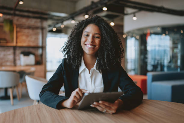 istock Young businesswoman using digital tablet looking at camera 1908370994