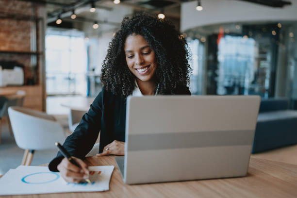 istock Young businesswoman using laptop at desk 1908371528
