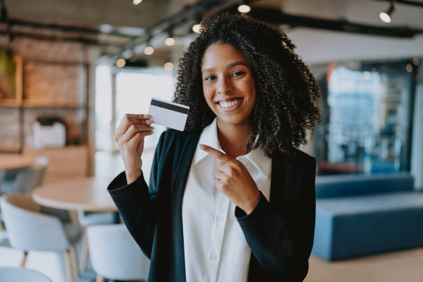 istock Young woman showing credit card 1908373666