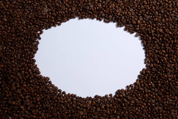 Roasted coffee beans with a circle Frame in the center on a white background. Top view with copy space for your text