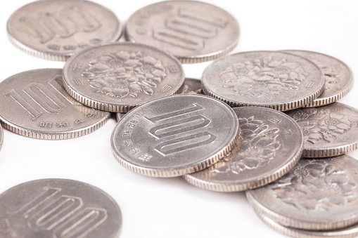 Pile of 100 yen coins japanese money on white background
