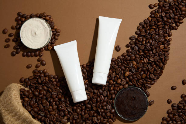 天然成分を使用したオーガニック化粧品を宣伝するための最小限のシーン。茶色の背景にコーヒー豆、コーヒーパウダー、クリームの質感、2つの化粧管のモックアップ。設計のための余白 - coffee bean cafe burlap sack burlap ストックフォトと画像