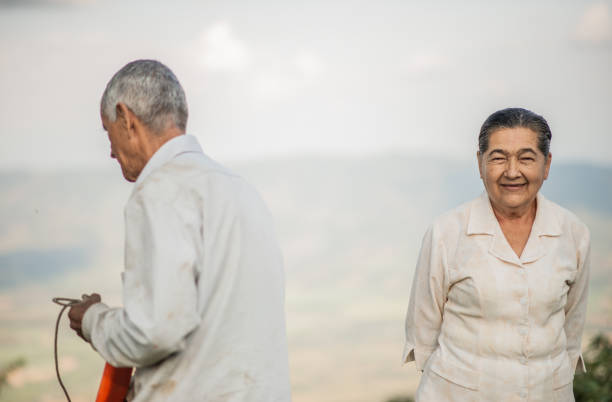portrait of a married couple outdoors while she is smiling and he is turning his back while smiling